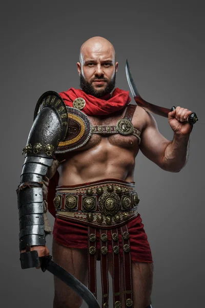 古罗马角斗士在灰色背景下身穿盔甲和斗篷被枪杀 — 图库照片