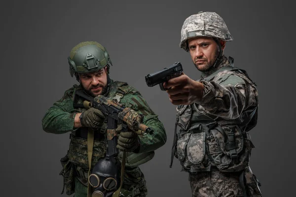 灰色の背景に孤立した銃を目指すロシアとNatoの兵士のショット — ストック写真