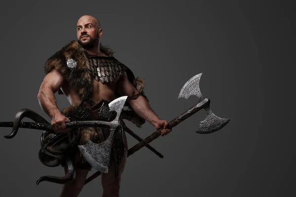 工作室拍摄的英俊的古代维京人身穿盔甲 手持两把斧头 — 图库照片