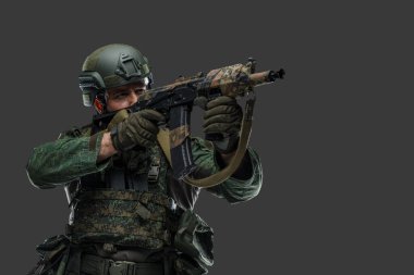 Modern kamuflaj üniforması giymiş silahlı bir Rus askerinin portresi..