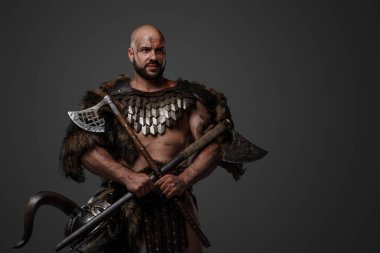 Geçmişten kana susamış Viking 'in görüntüsü. Zırh ve kürk giymiş gri arka planda..