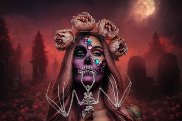 Portrait of glamour evil woman with wreath of roses and bat skeleton in cemetery.