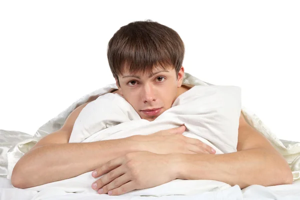 Człowiek tulenie poduszki leżąc na łóżku — Zdjęcie stockowe