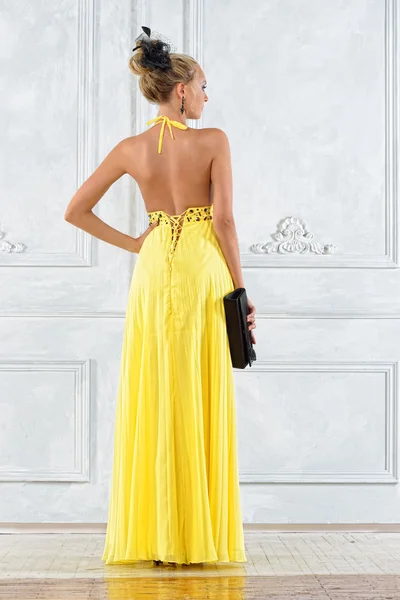 Vacker blond kvinna i en lång gul klänning. — Stockfoto
