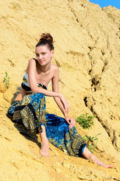 Vacker kvinna sitter på sanden — Stockfoto