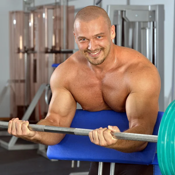 Çıplak gövde, barbell ile egzersiz ile güçlü bir adam. — Stok fotoğraf