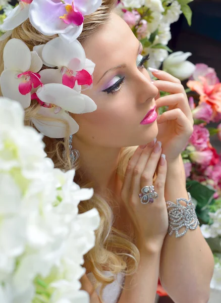 Hermosa mujer elegante alrededor de las flores . — Foto de Stock