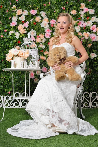 Hermosa mujer en vestido de novia en el jardín con flores . — Foto de Stock