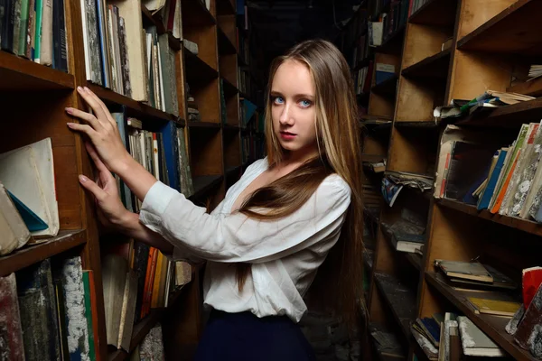 Bella donna che sceglie il libro in biblioteca . — Foto Stock