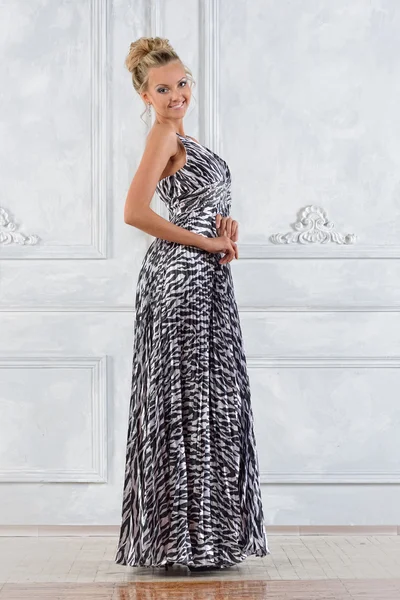 Vacker kvinna i zebra mönstrad lång klänning i vit inredning. — Stockfoto