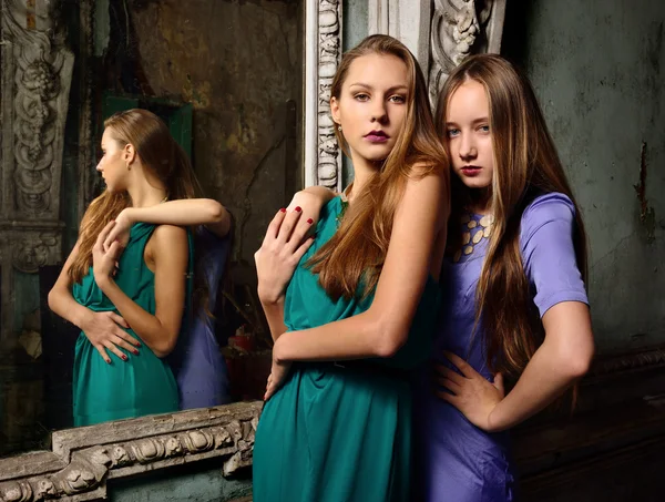 Two beautiful women posing in obsolete interior. — Stock Photo, Image