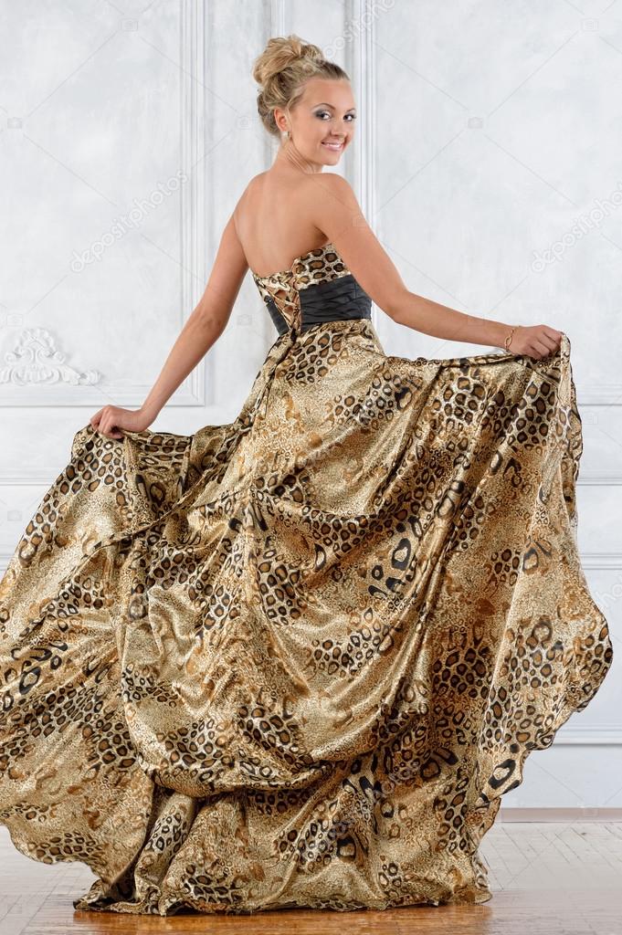 Beautiful bonde woman in leopard patterned long dress.