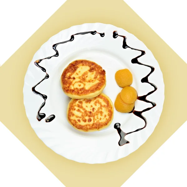 Dish of pancakes with dried apricot on white plate. — Stock Photo, Image