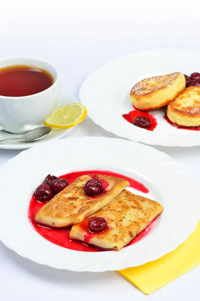 Food of Crepes, cheesecakes with berry sause and cup of tee. — Stock Photo, Image