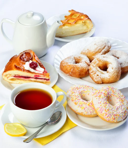 Ainda vida de mesa de treino com tortas de cozimento, rosquinhas, xícara de chá e — Fotografia de Stock