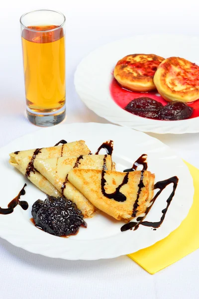 Food of crepes, cheesecakes with berry sause and glass of juice. — Stock Photo, Image