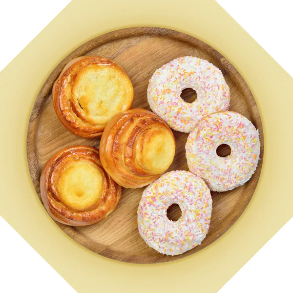Wooden dish of cheese pies and donuts. — Stock Photo, Image