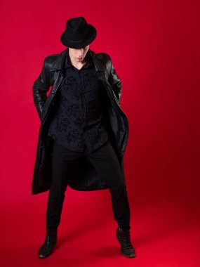 Siyah elbiseli genç, karizmatik bir adam, bir kara filmin kahramanı.,