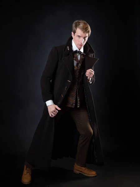 Karakter a steampunk történet, egy fiatal vonzó férfi elegáns hosszú kabátban — Stock Fotó