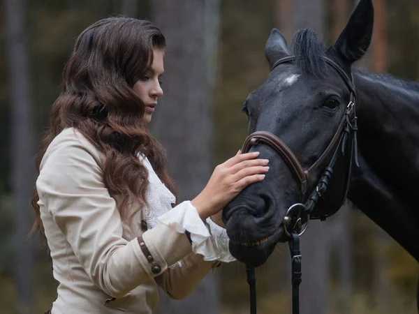 Portret jeźdźca w garniturze retro i jej czarnego konia. — Zdjęcie stockowe