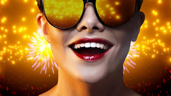 Férias. Reflexão de fogos de artifício brilhantes em óculos de uma jovem mulher feliz, — Fotografia de Stock