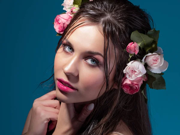 Una giovane bella donna con fiori di rosa tra i capelli bagnati. — Foto Stock