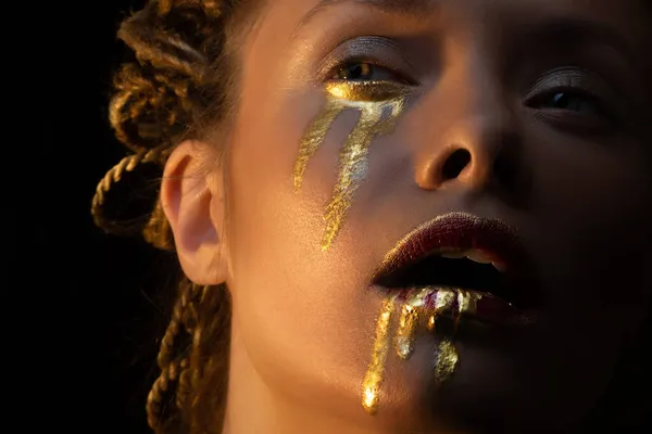 Złoto na skórze, sztuka twarzy i twórczy makijaż, złoto jak łzy i krew — Zdjęcie stockowe