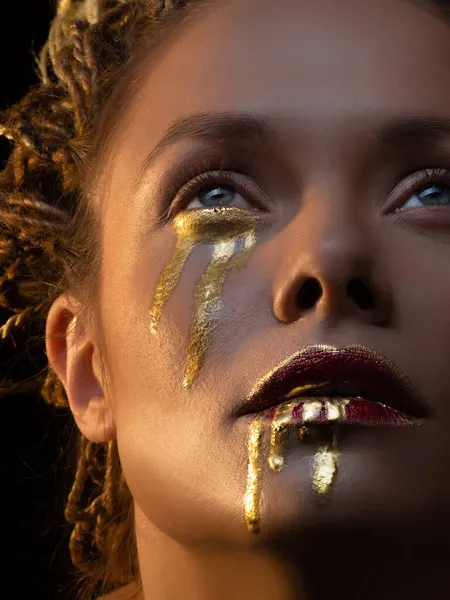 Guld på huden, ansiktskonst och kreativ makeup, guld som tårar och blod — Stockfoto