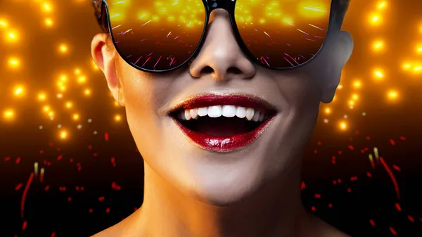 A beautiful young woman in sunglasses looks at the fireworks in delight, — Stock Photo, Image
