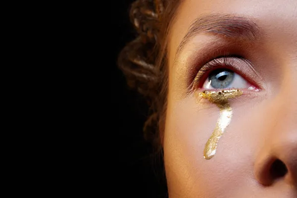 Lágrimas douradas, retrato glamouroso em estilo escuro, olho azul com uma lágrima dourada — Fotografia de Stock