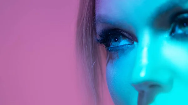 Blick, öga närbild, ung kvinna i neon blå bakgrundsbelysning — Stockfoto