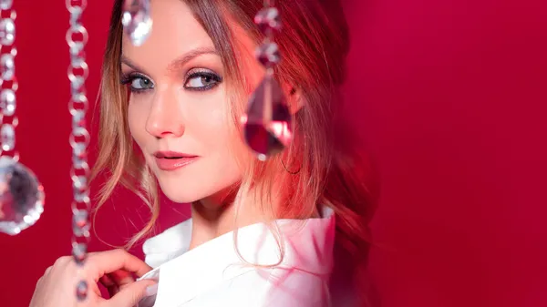 Porträt einer hinreißenden jungen Blondine zwischen funkelnden Kristallen, rosa Tönen und Licht. — Stockfoto