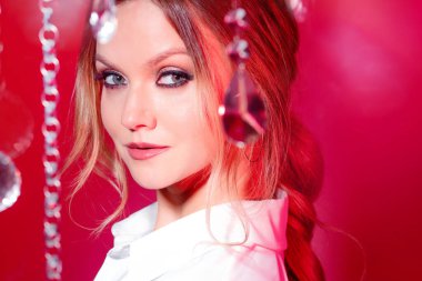 Işıl ışıl kristallerin, pembe tonların ve aydınlığın arasında genç ve güzel bir sarışın portresi..