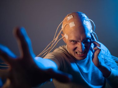 Kafası kabloya dolanmış korkunç bir genç adam zihin kontrolü kullanıyor.