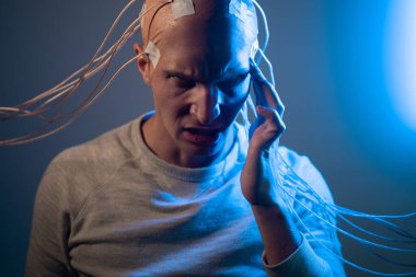 Kafası tellere dolanmış, acı ve ıstırap çeken genç bir adam.