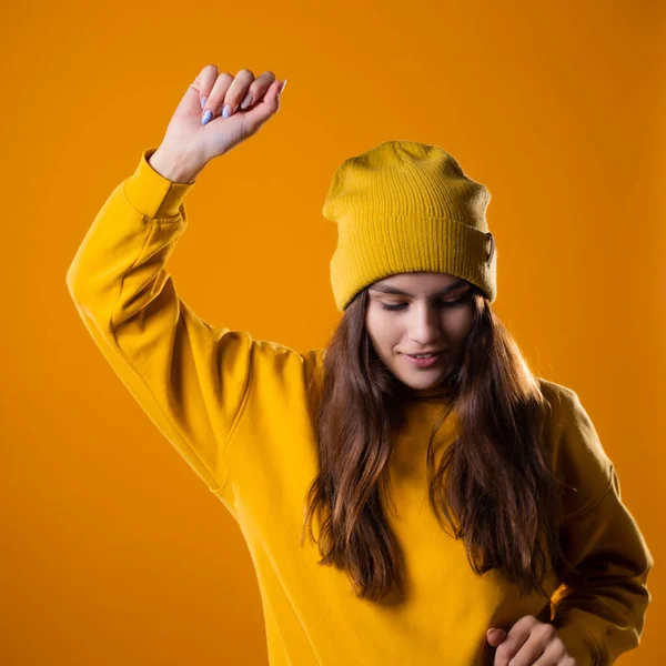 Een jong vrolijk brunette in heldere kleren is dansen en plezier hebben. — Stockfoto