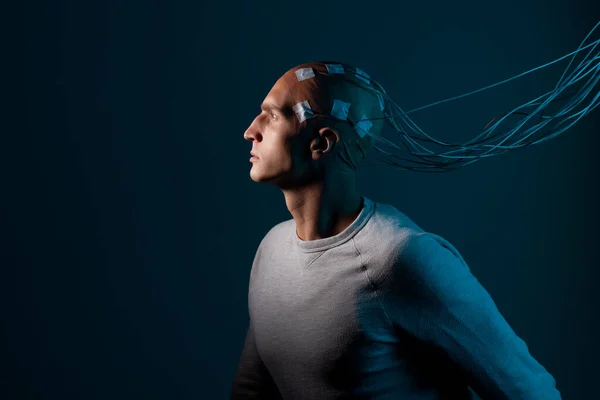 Un joven con la cabeza enredada con cables, un retrato de perfil, — Foto de Stock