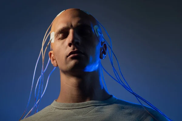 Un joven con la cabeza enredada con cables, un retrato — Foto de Stock