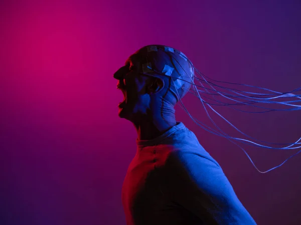 A young man with his head entangled in wires, screaming — Stock Photo, Image