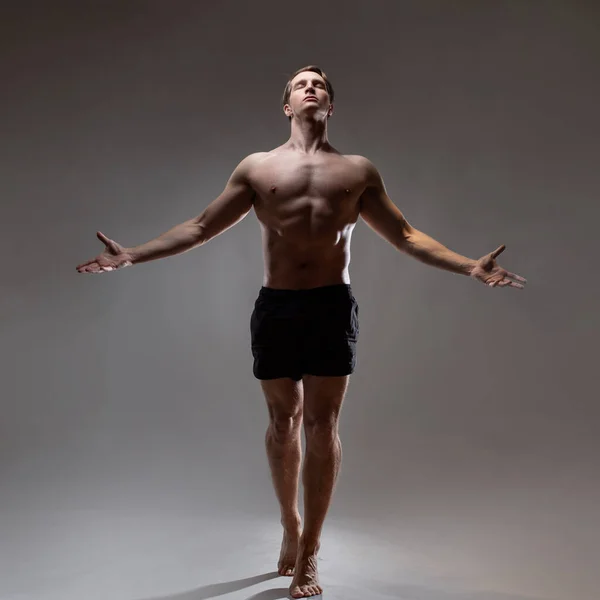 Um jovem homem musculoso em uma pose expressiva. Belos músculos. — Fotografia de Stock
