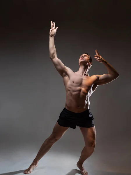 En ung muskulös man i uttrycksfull posering. Vackra muskler. — Stockfoto