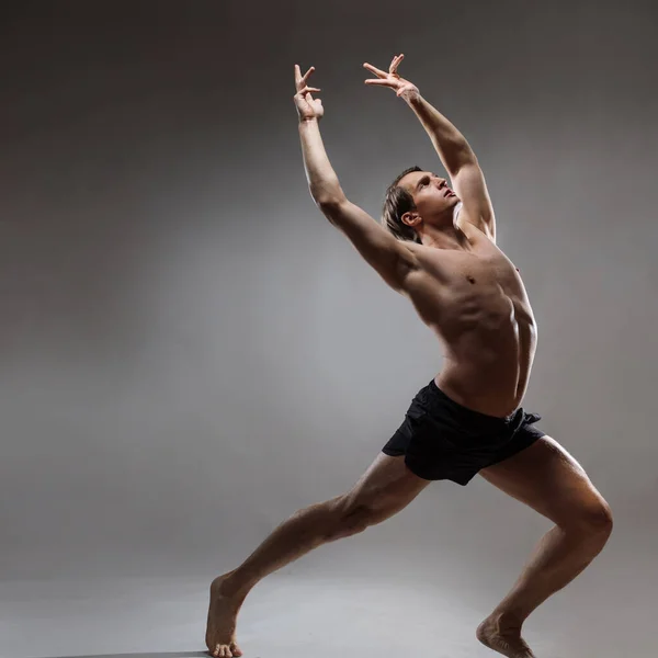 Um jovem homem musculoso em uma pose expressiva. Belos músculos. — Fotografia de Stock