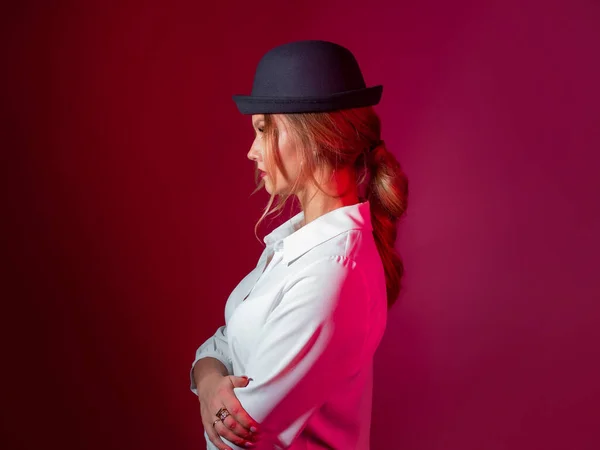 Una giovane donna elegante con una camicia bianca e un cappello a bombetta nero, stile rigoroso, — Foto Stock