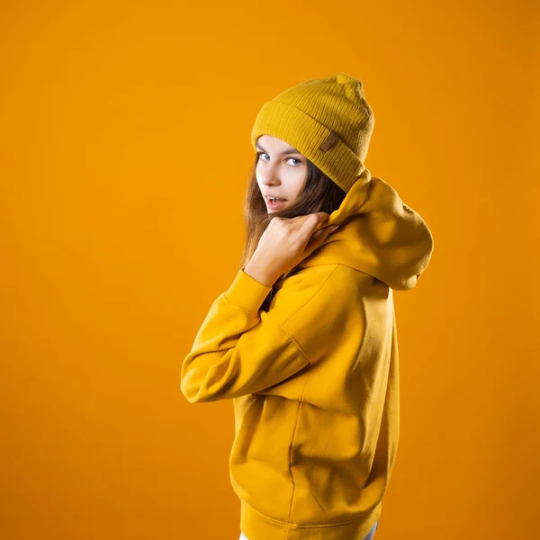 Een jong vrolijk brunette in heldere kleren is dansen en plezier hebben. — Stockfoto