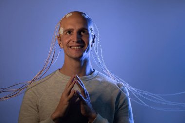 Kafası kabloya dolanmış korkunç bir genç adam.,