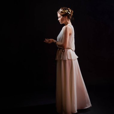 Antik Yunan tanrıçasının ya da ilham perisinin suretinde genç bir kadın..