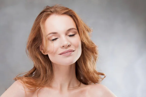 Een jonge roodharige vrouw geniet van de schoonheid van haar haar, — Stockfoto