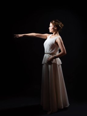 Eski kahraman suçlayacak birini işaret ediyor. Yunan tarzında bir kadın