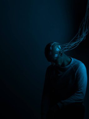 Kafası kabloya dolanmış, kafası kopmuş, başı aşağıda oturan genç bir adam.,