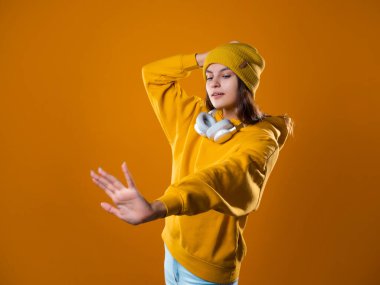 Bir müzik aşığı, parlak elbiseli neşeli bir esmer müzik dinliyor.